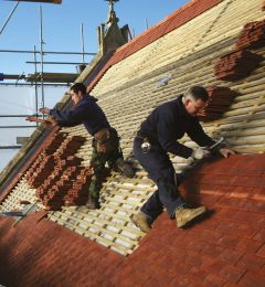 Photo of new tiles being attached to roof of chapel
