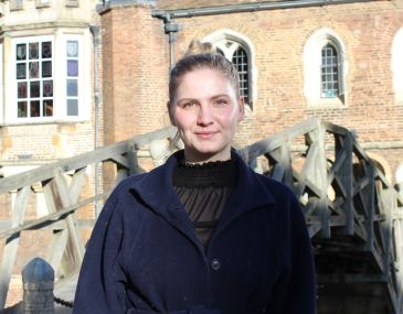 Girl in a navy blue coat in front of the Mathematical Bridge